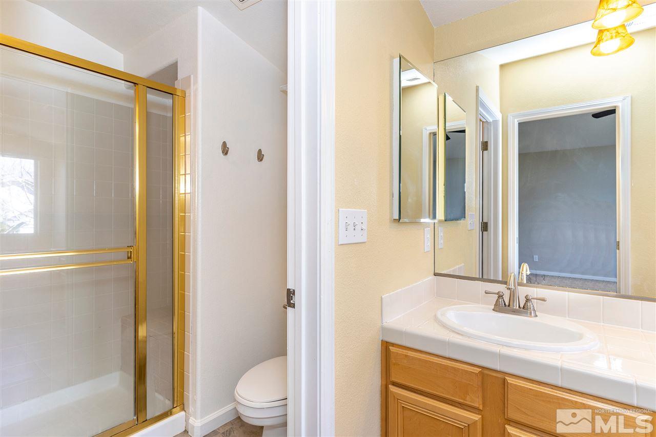 805 Caughlin Crossing Reno, NV 89519 - Photo 15 of 31 a bathroom with a granite countertop sink toilet and shower