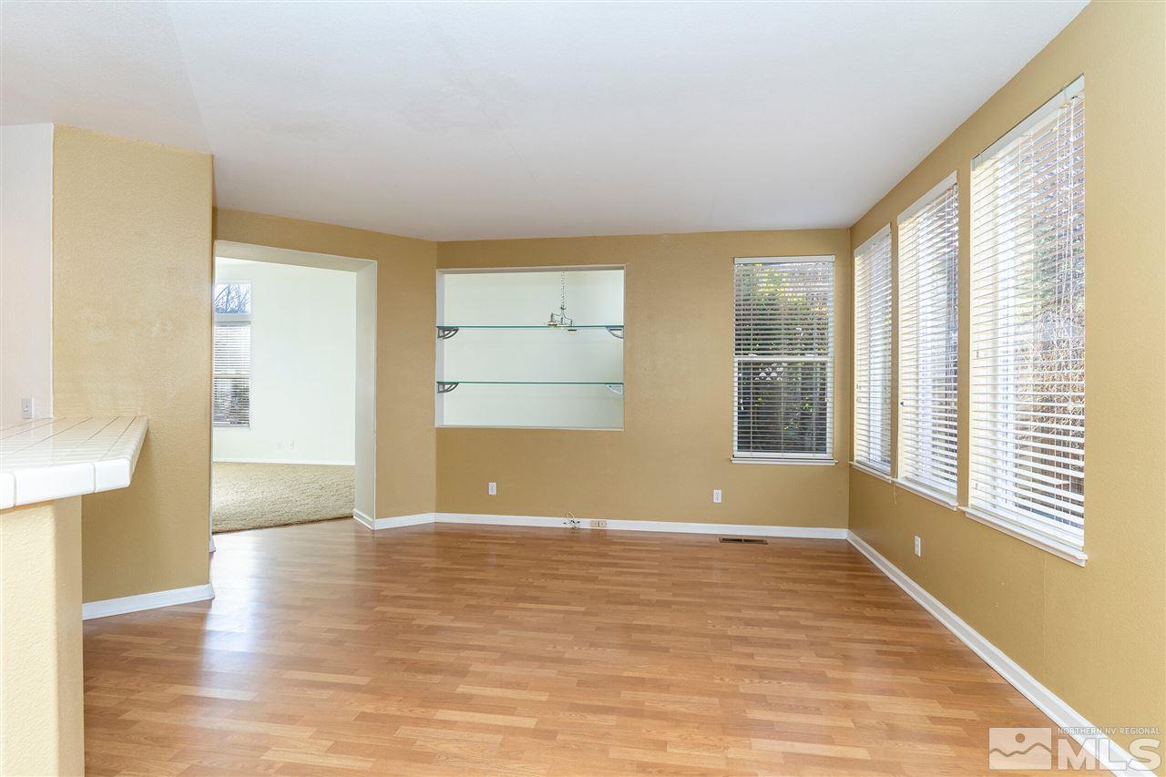 805 Caughlin Crossing Reno, NV 89519 - Photo 6 of 31 a view of an empty room with wooden floor and a window