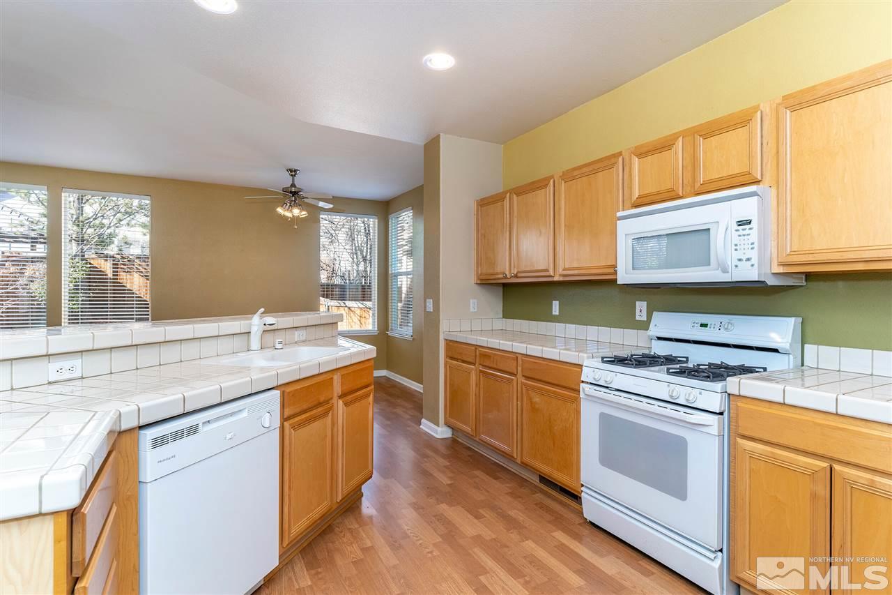 805 Caughlin Crossing Reno, NV 89519 - Photo 10 of 31 a kitchen with stainless steel appliances granite countertop wooden cabinets stove and sink