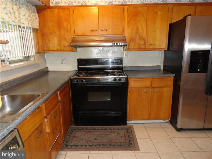 30 Sunshine Road Upper Darby, PA 19082 - Photo 8 of 18 a kitchen with a stove top oven cabinets and a refrigerator