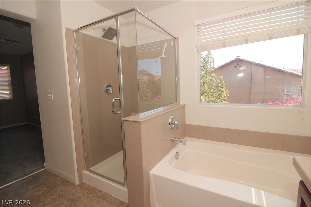 9289 Valley Ranch Avenue Las Vegas, NV 89178 - Photo 16 of 29 Indulge in a corner soaking tub and glass-enclosed shower, perfect for unwinding.