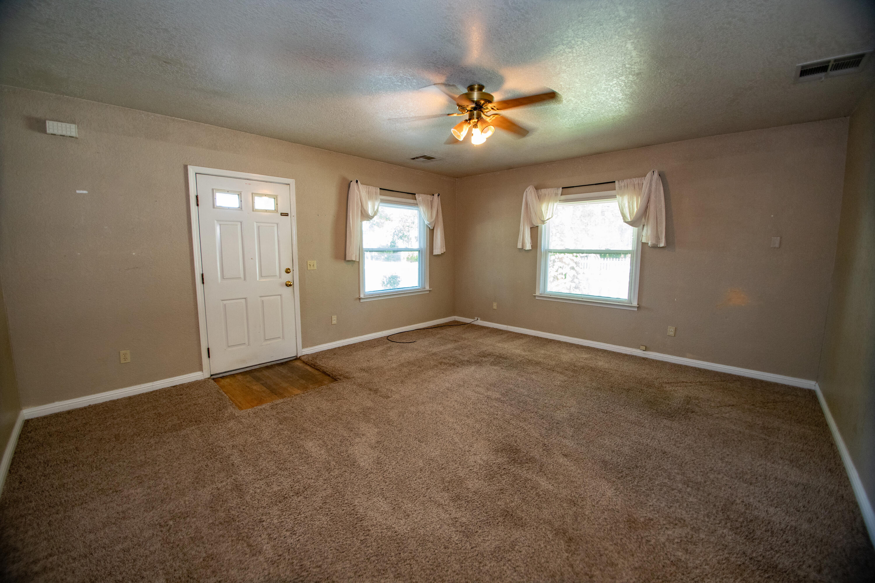 856 State Street Redding, CA 96001 - Photo 12 of 13 an empty room with windows and chandelier fan