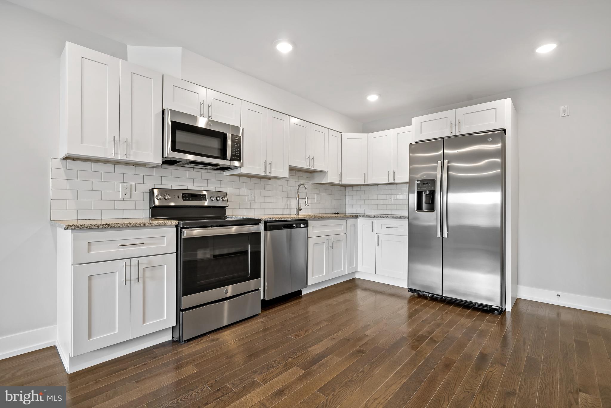 1530 Palethorp Street, Unit 2B Philadelphia, PA 19122 - Photo 1 of 15 a kitchen with stainless steel appliances granite countertop a refrigerator a stove top oven a sink and cabinets