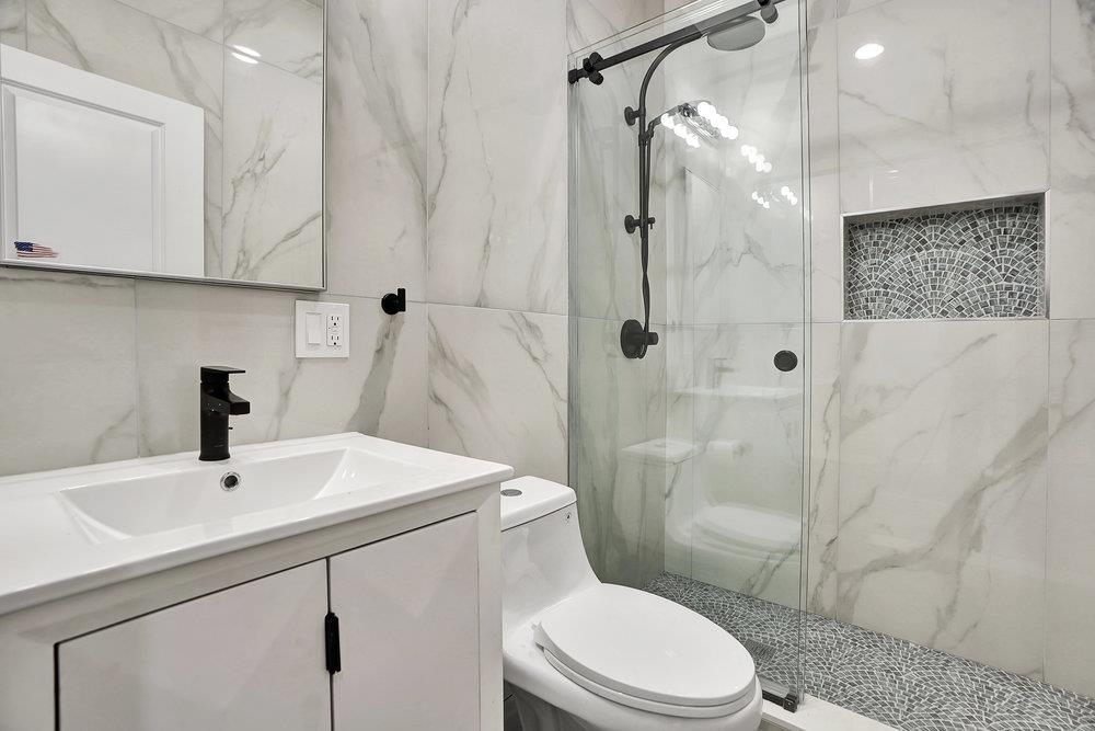 34 Van Reypen Street, Unit 2 Jersey City, NJ 07306 - Photo 14 of 25 a bathroom with a sink toilet and shower