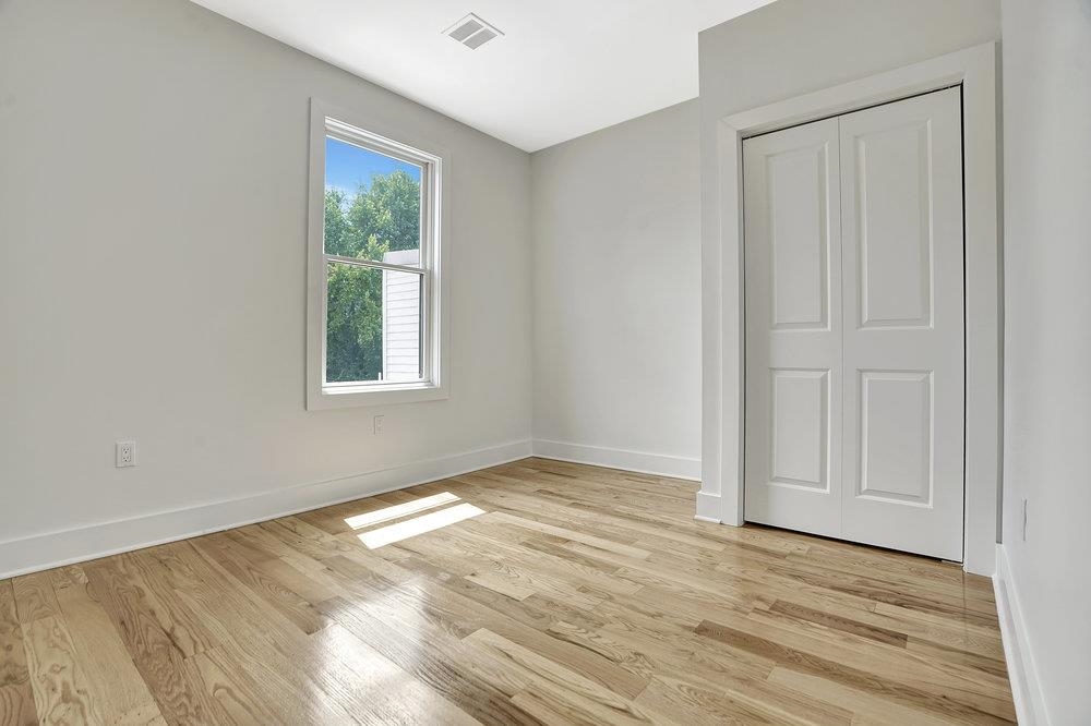 34 Van Reypen Street, Unit 2 Jersey City, NJ 07306 - Photo 15 of 25 an empty room with wooden floor and windows