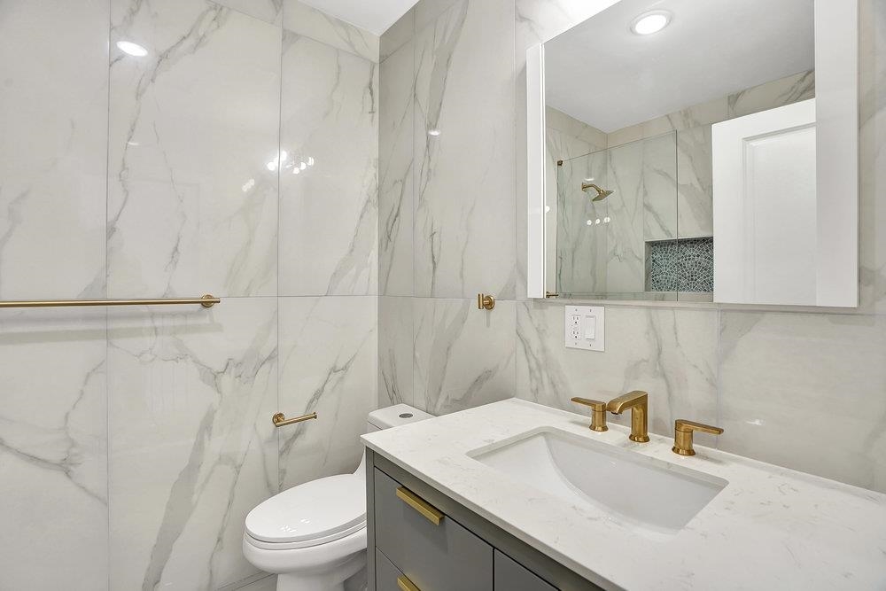 34 Van Reypen Street, Unit 2 Jersey City, NJ 07306 - Photo 19 of 25 a bathroom with a sink toilet vanity and shower