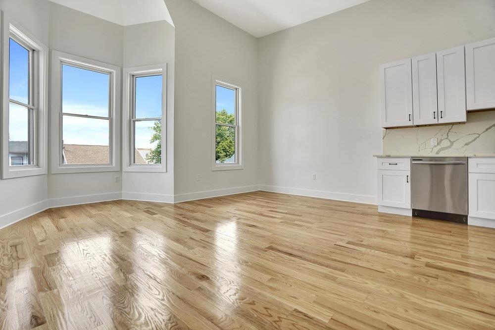 34 Van Reypen Street, Unit 2 Jersey City, NJ 07306 - Photo 5 of 25 an empty room with wooden floor and windows