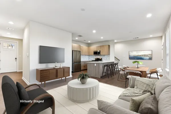 a living room with furniture kitchen view and a flat screen tv