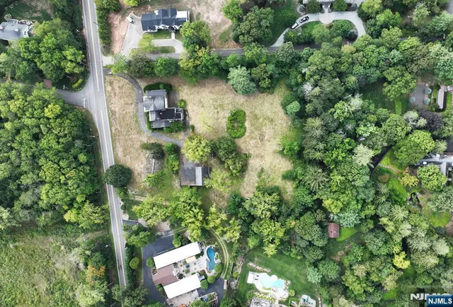 an aerial view of residential house with outdoor space and trees all around