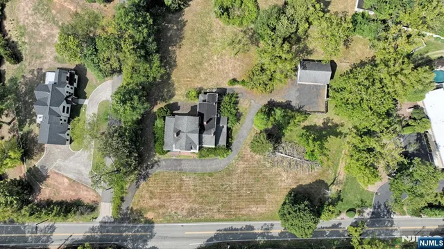 an aerial view of a house with trees all around