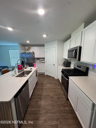 a large kitchen with lots of counter space and wooden floor