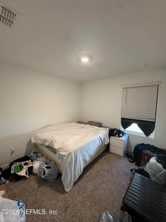 a bedroom with bed and a window