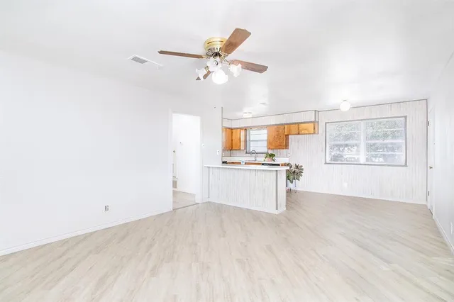 a view of a kitchen with wooden floor and a ceiling fan