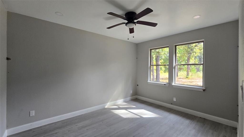 228 East Acres Road Gun Barrel City, TX 75156 - Photo 12 of 25 an empty room with a window and a fan