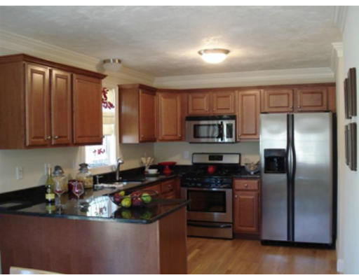 126 Smith Street, Unit 1 Lowell, MA 01851 - Photo 3 of 19 a kitchen with stainless steel appliances granite countertop a refrigerator a stove top oven a sink and dishwasher