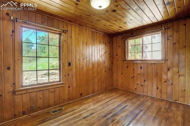 a backyard of a house with a swing chair and entertaining space