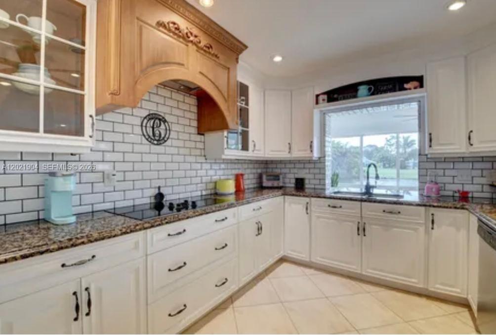 3324 Lakeview Boulevard Delray Beach, FL 33445 - Photo 12 of 36 a kitchen with granite countertop white cabinets and white appliances