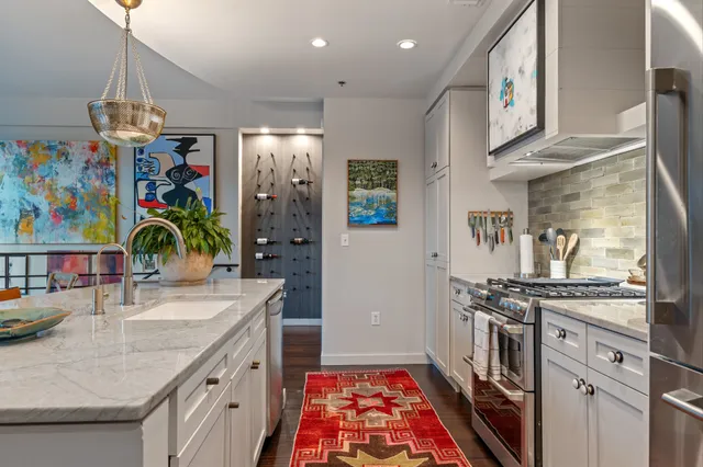 a view of a hallway with wooden floor and paintings on the wall