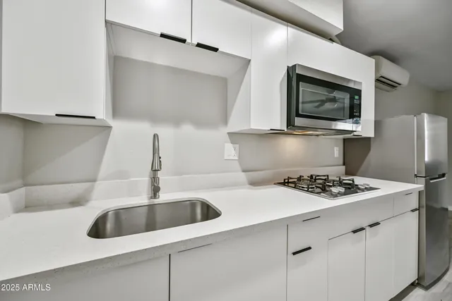 a kitchen with a sink a refrigerator and cabinets