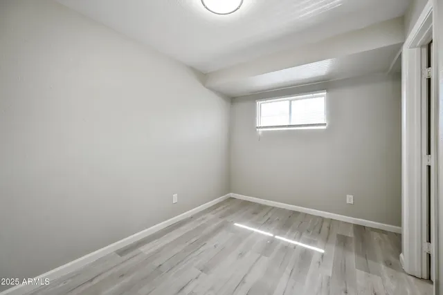 a view of a room that has wooden floor and cabinets