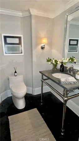 a living room with a toilet a sink and a table
