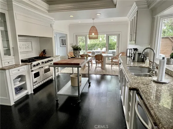 a kitchen with stainless steel appliances granite countertop a stove a sink dishwasher and cabinets with wooden floor