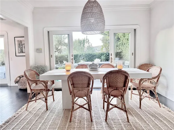 a dining room with furniture a chandelier and wooden floor