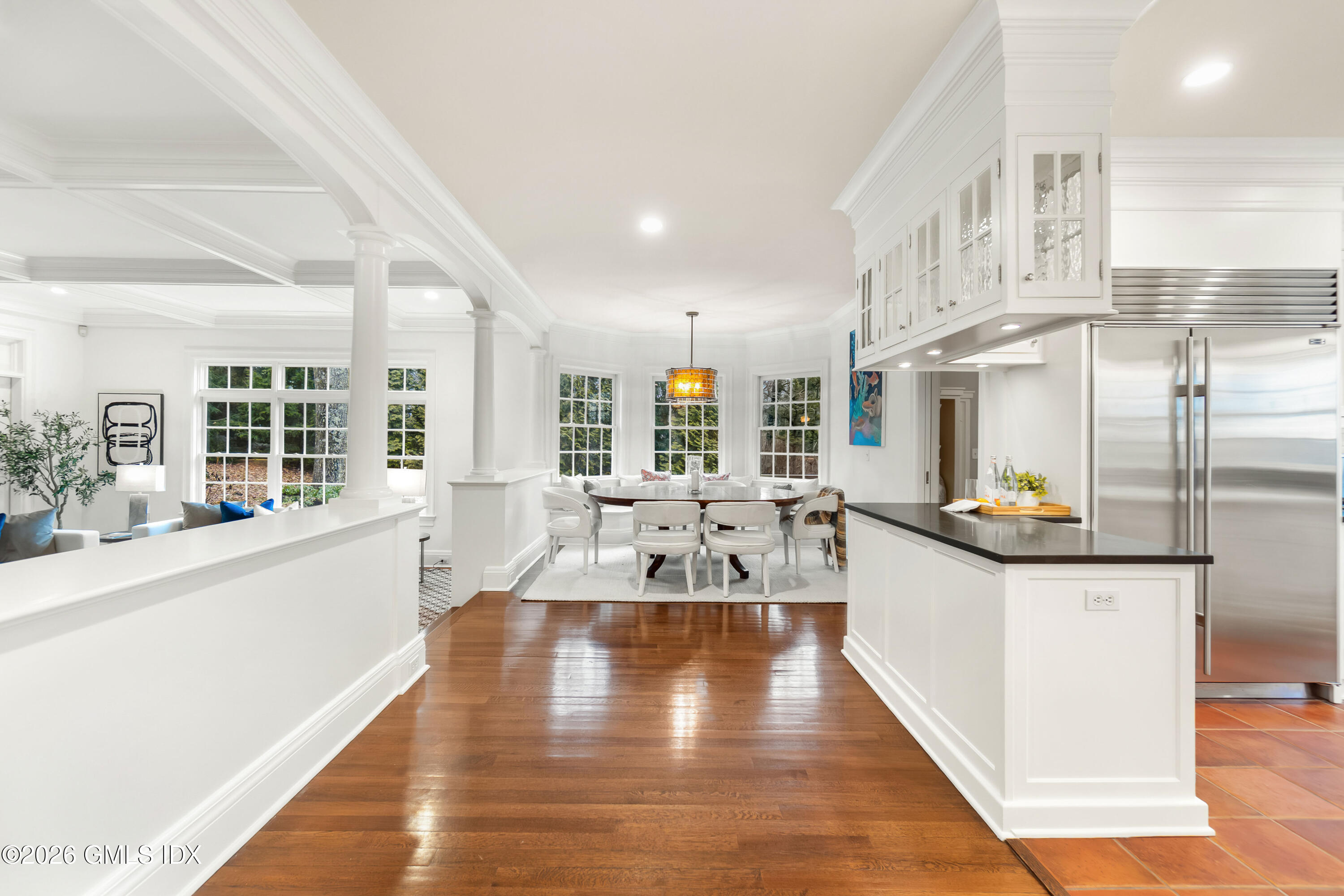 63 Wesskum Wood Road Riverside, CT 06878 - Photo 12 of 26 a large white kitchen with stainless steel appliances kitchen island granite countertop a large kitchen island a stove a sink a refrigerator and white cabinets with wooden floor