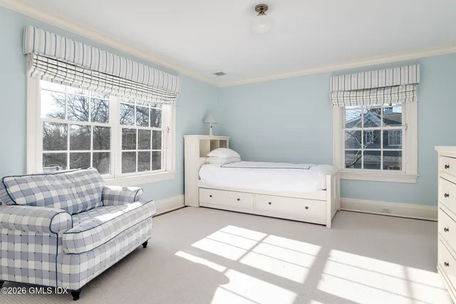 a bedroom with a bed and a large window