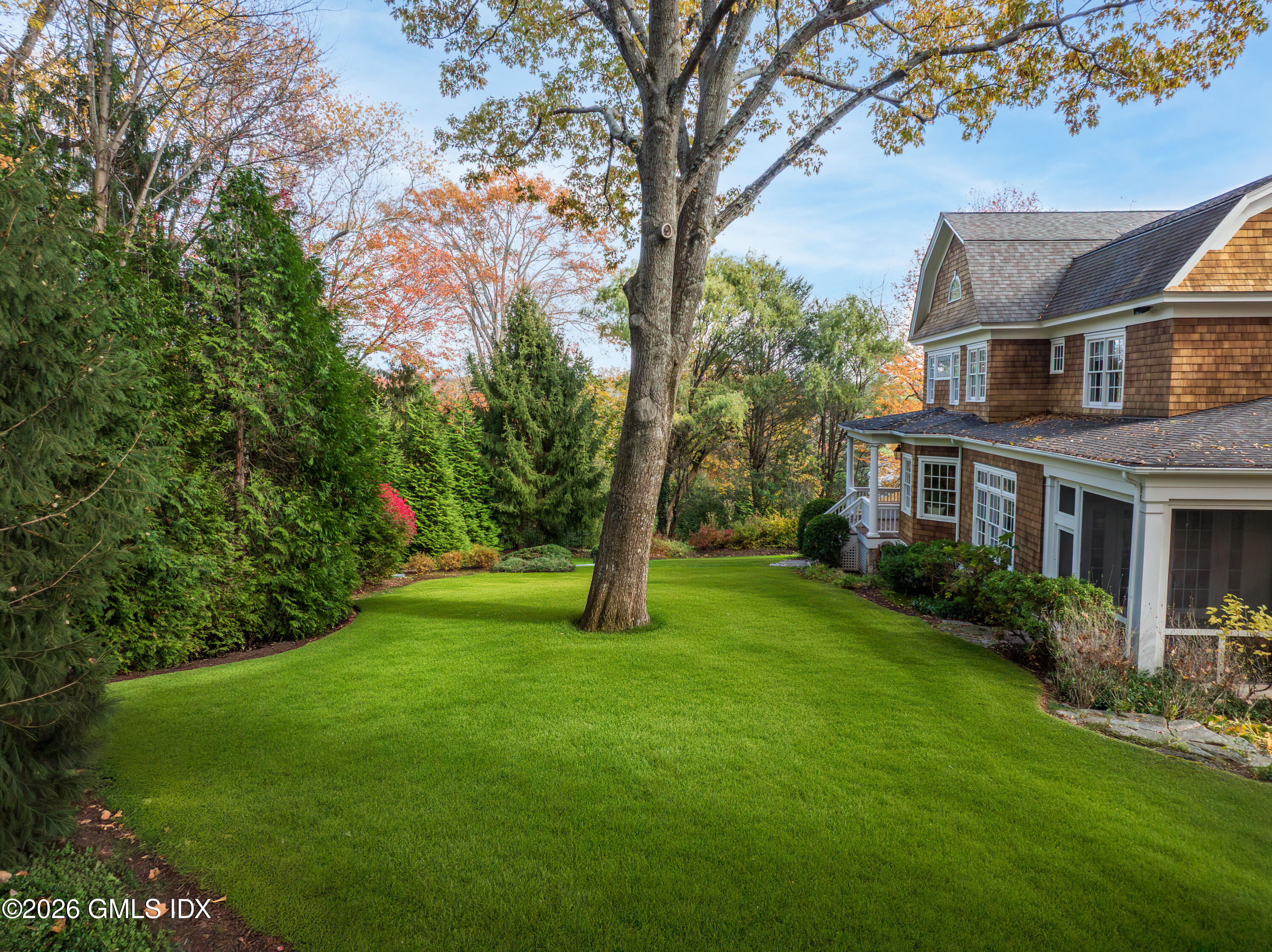 63 Wesskum Wood Road Riverside, CT 06878 - Photo 25 of 26 a view of a big yard in front of a brick house with large windows