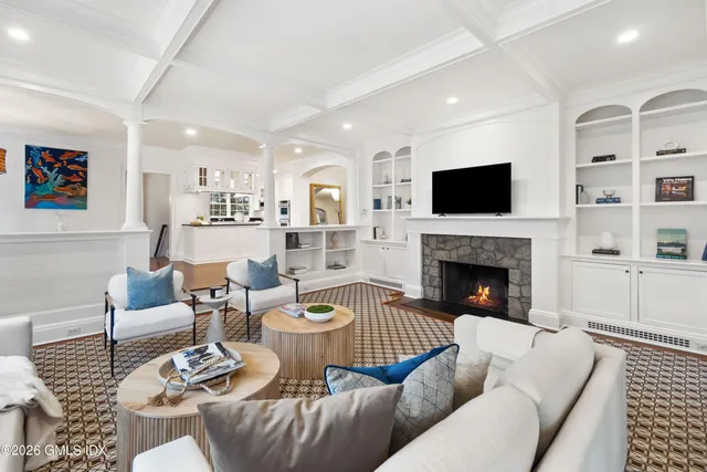a living room with furniture a flat screen tv and a fireplace