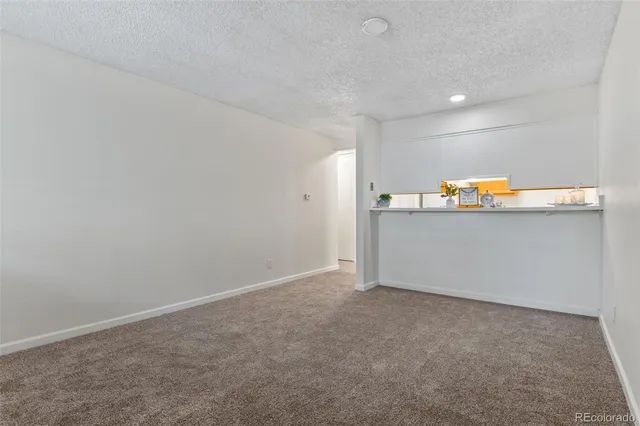 a view of a room with wooden floor and white walls