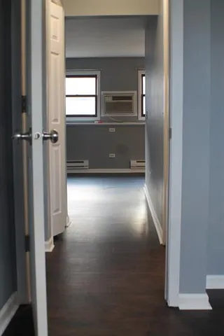 a view of kitchen and hallway with wooden floor