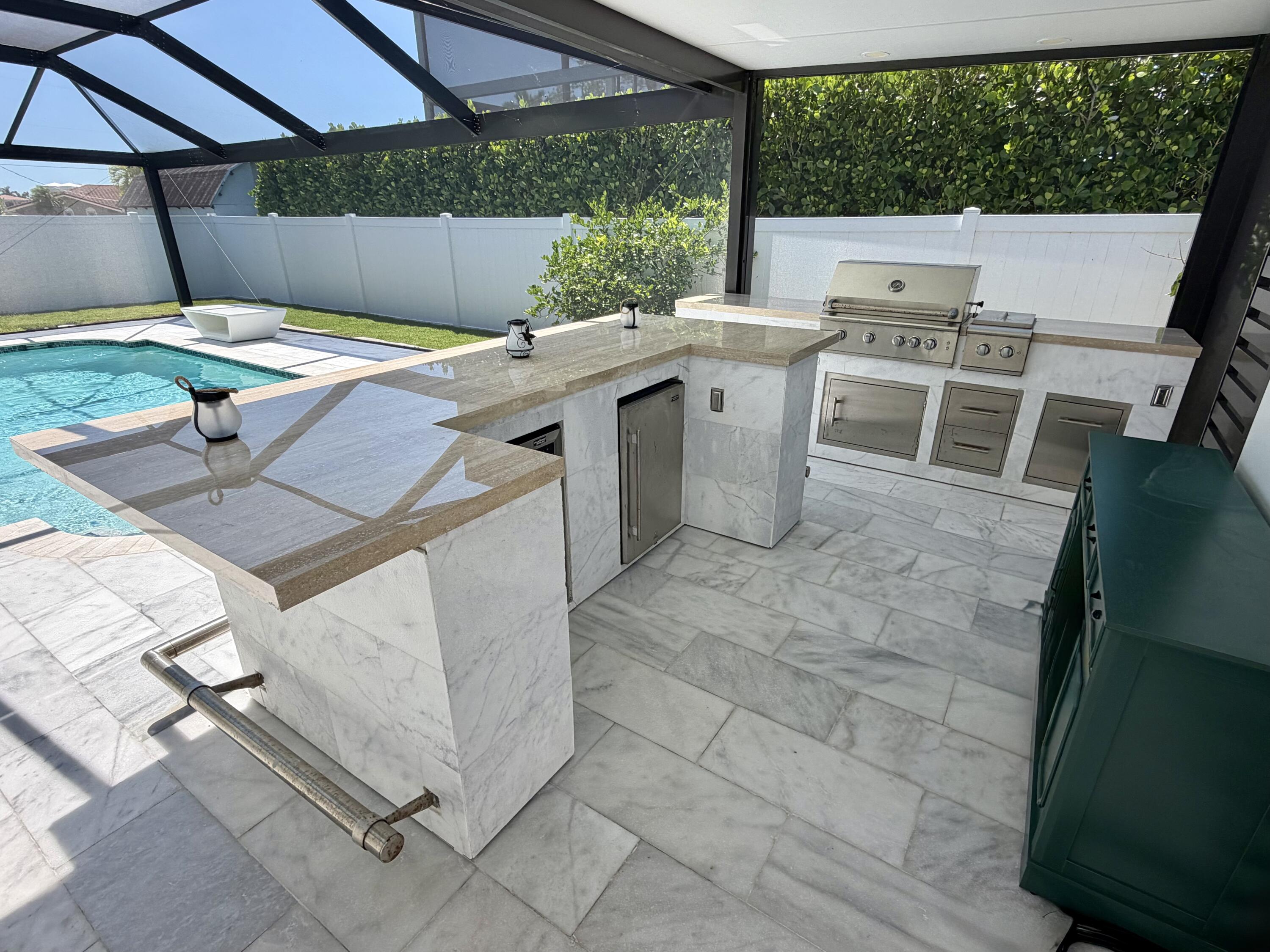 112 Capri Boulevard Naples, FL 34113 - Photo 23 of 29 a view of a patio with table and chairs under an umbrella