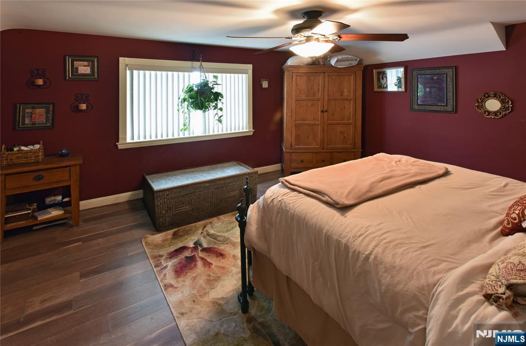 585 Monroe Place Ridgefield, NJ 07657 - Photo 12 of 28 a bedroom with a bed dresser and wooden floor