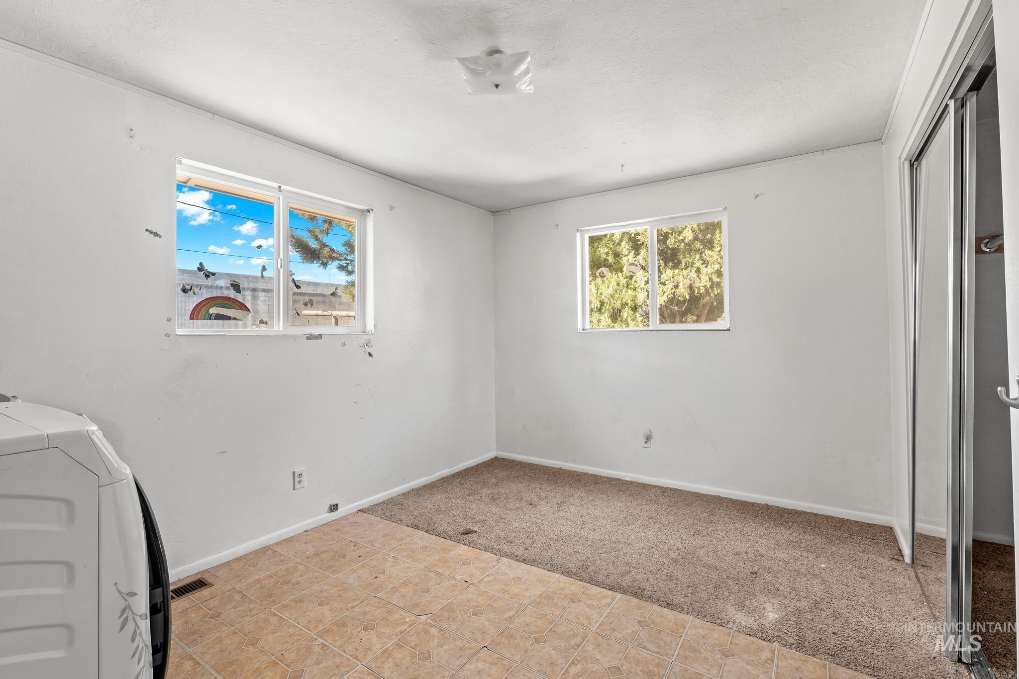 6295 West Grandview Place Boise, ID 83709 - Photo 15 of 29 Unfurnished bedroom featuring light colored carpet, light tile patterned floors, a closet, and washer and dryer