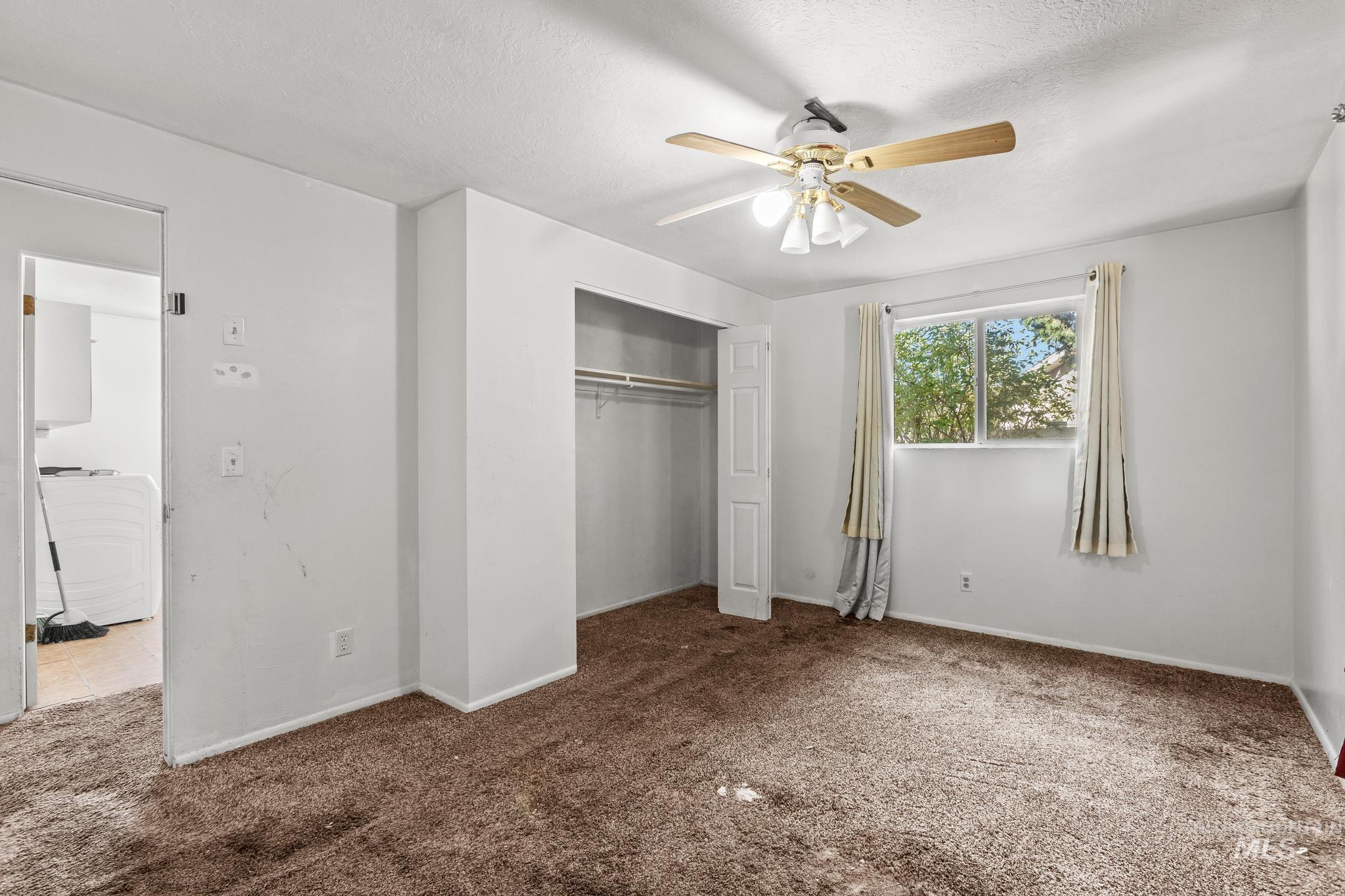 6295 West Grandview Place Boise, ID 83709 - Photo 18 of 29 Unfurnished bedroom featuring carpet, a closet, a ceiling fan, and a textured ceiling