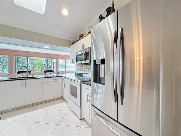 a kitchen with white cabinets and white appliances