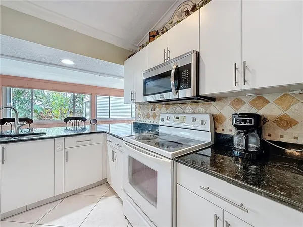 a kitchen with stainless steel appliances granite countertop a sink stove and microwave
