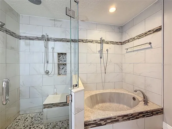 a bathroom with a granite countertop bathtub shower and toilet