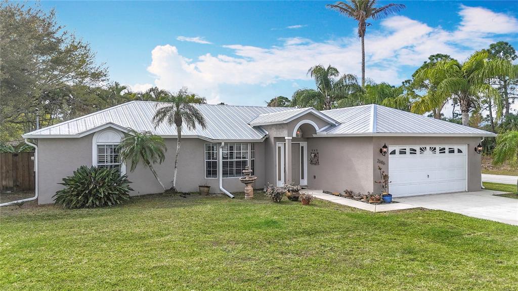 2686 Southwest Fairgreen Road Port St. Lucie, FL 34987 - Photo 2 of 36 a view of a house with a yard and potted plants