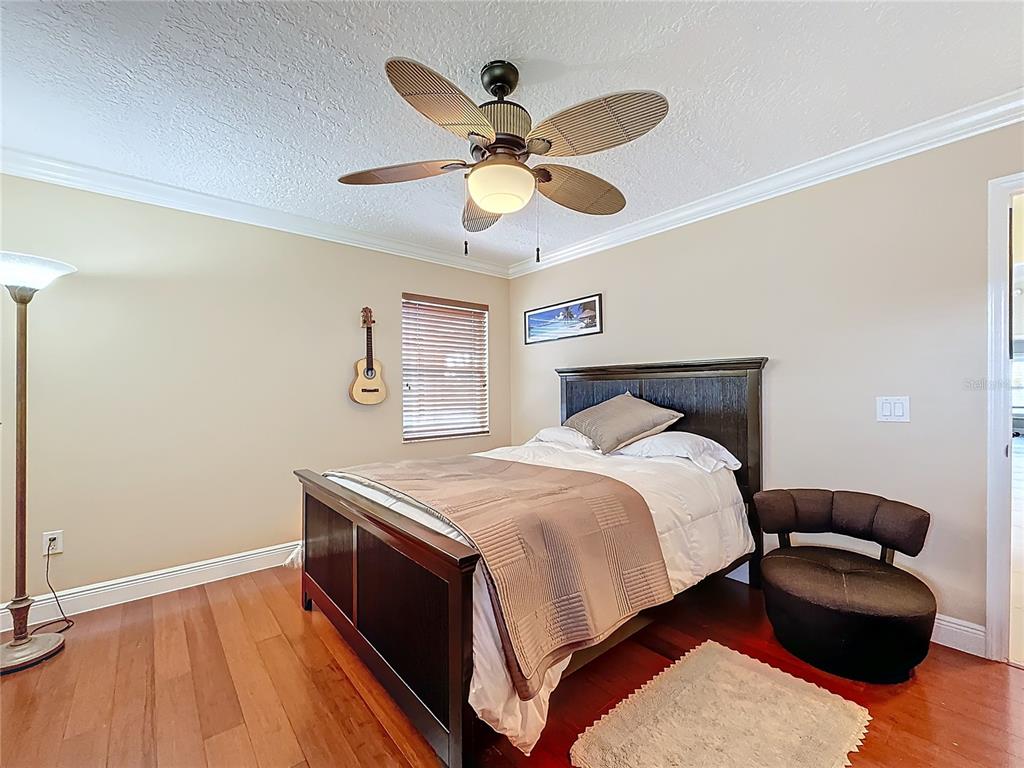 2686 Southwest Fairgreen Road Port St. Lucie, FL 34987 - Photo 21 of 36 a bedroom with a bed and ceiling fan