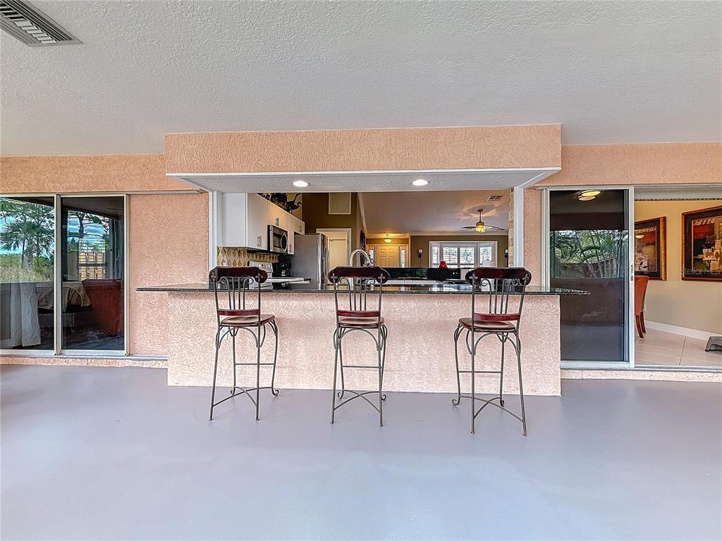 2686 Southwest Fairgreen Road Port St. Lucie, FL 34987 - Photo 27 of 36 a kitchen with stainless steel appliances kitchen island lots of white furniture a dining table and chairs
