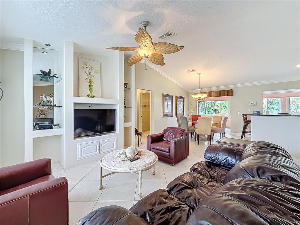 2686 Southwest Fairgreen Road Port St. Lucie, FL 34987 - Photo 5 of 36 a living room with furniture a fireplace and a flat screen tv