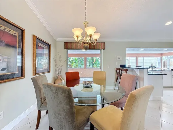 a view of a dining room with furniture a chandelier and wooden floor