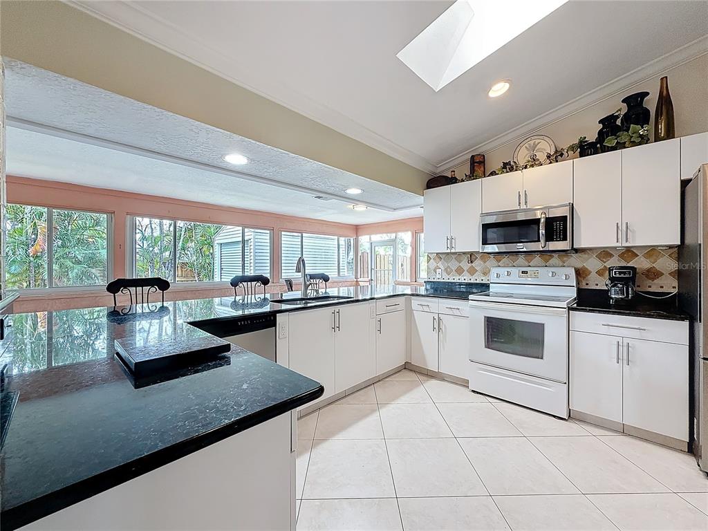 2686 Southwest Fairgreen Road Port St. Lucie, FL 34987 - Photo 10 of 36 a kitchen with stainless steel appliances granite countertop a sink counter space cabinets and a window