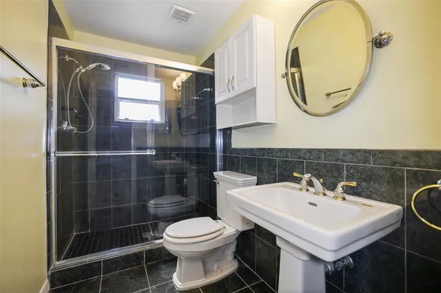 a bathroom with a sink a toilet and a mirror