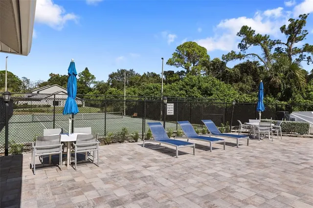 a view of a patio with table and chairs next to a yard