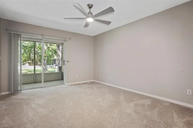 an empty room with a ceiling fan and windows