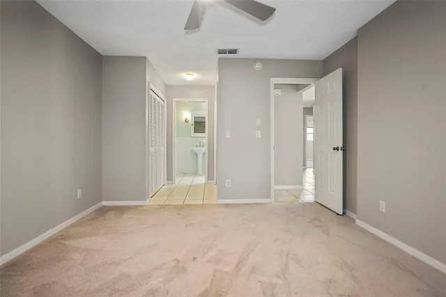 an empty room with fan and entrance